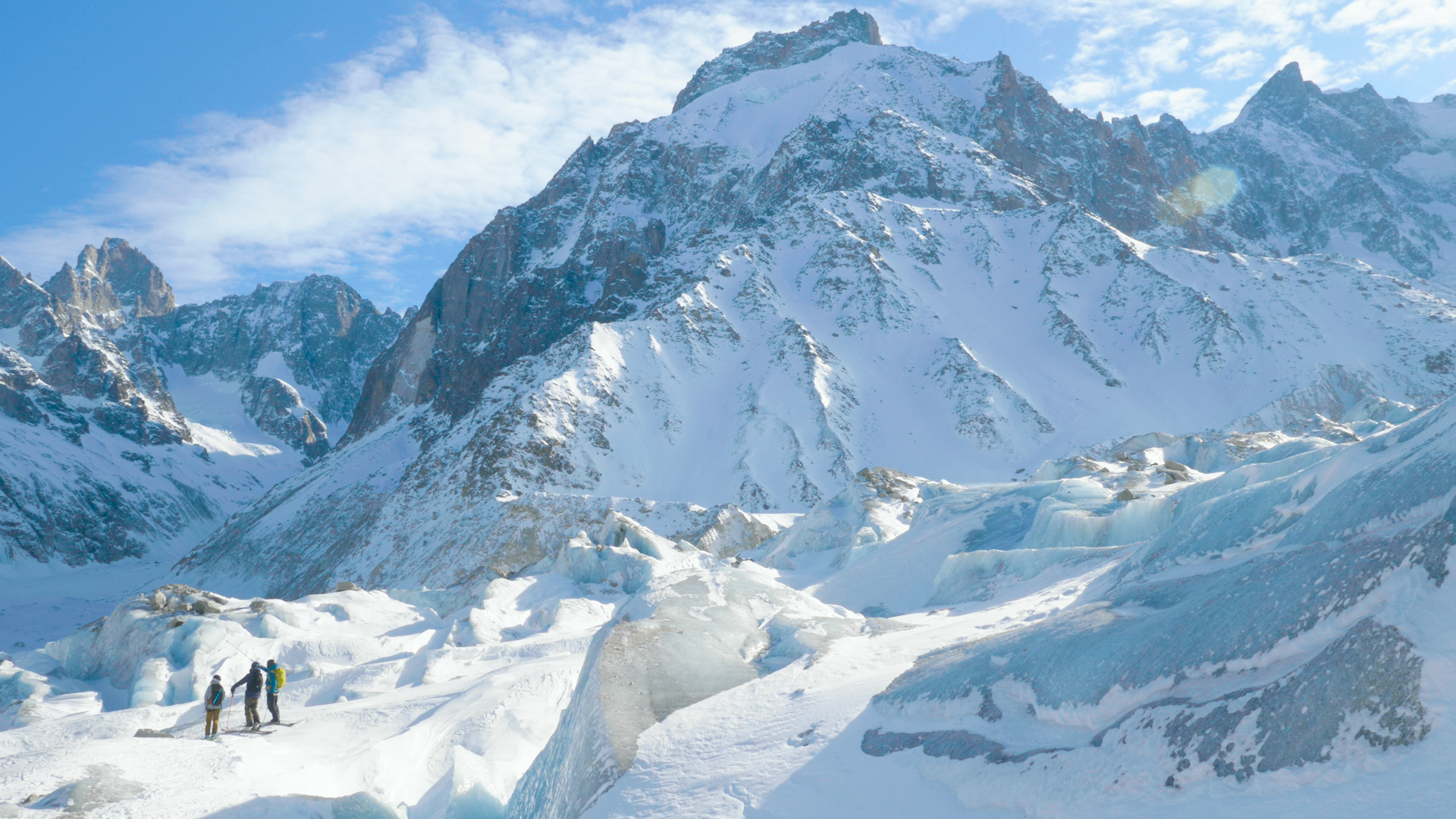 A view of three skiers admiring glaciers and seracs in Chamonix's Vallee Blanche