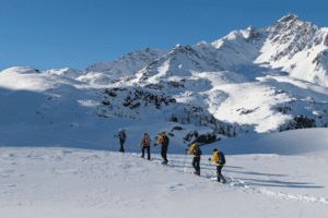 Group of people ski touring and splitboarding